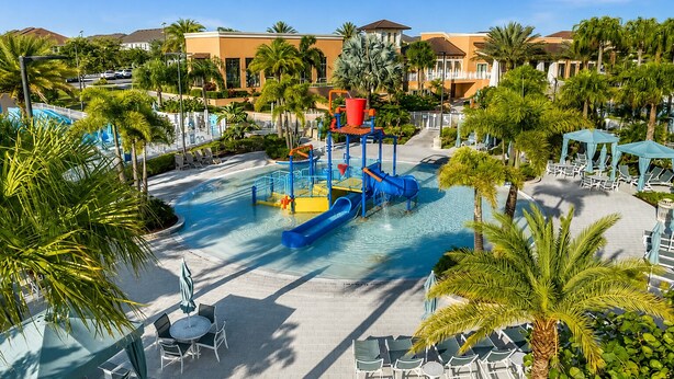 Un parc aquatique avec des toboggans et une zone de piscine, entouré de palmiers et de chaises longues.