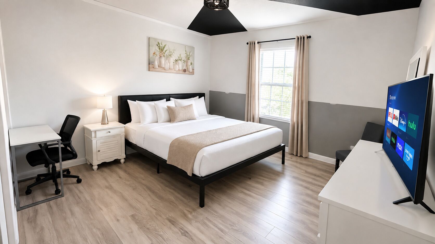 A modern bedroom with a bed, bedside tables, a desk, and a TV.