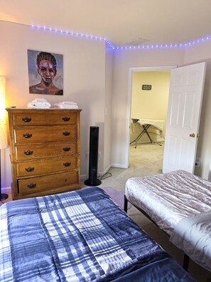 Un dormitorio con cama, cómoda y un cuadro en la pared.