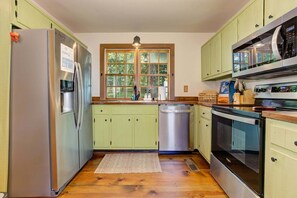 A compact kitchen with a refrigerator, dishwasher, microwave, and oven. - Amazing Grace - Expansive Open-Air Deck, Long-Range Views + Big Canoe Access (Jasper)