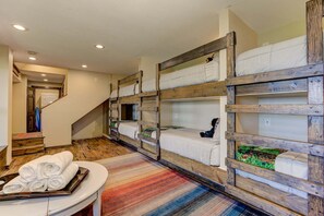 A hotel room with bunk beds, a staircase, and a table with towels. - Amazing Grace - Expansive Open-Air Deck, Long-Range Views + Big Canoe Access (Jasper)