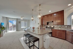 A modern kitchen with a central island, wooden cabinets, and a large window. - 2700SF Sweet HOME｜Pool Table｜Near Strip｜King Bed (Las Vegas)