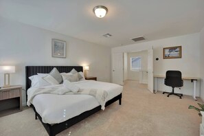 A bedroom with a bed, bedside tables, a desk, and a chair. - 2700SF Sweet HOME｜Pool Table｜Near Strip｜King Bed (Las Vegas)
