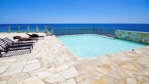 A swimming pool with stone flooring and a view of the ocean. - 16th-Floor Oceanfront Condo with Stunning Sunset Views (Playas de Rosarito)