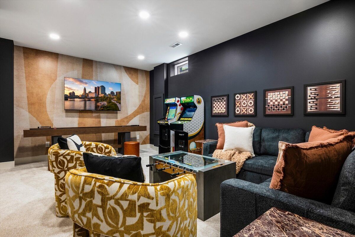 A modern living room with a sofa, a coffee table, and a foosball table.