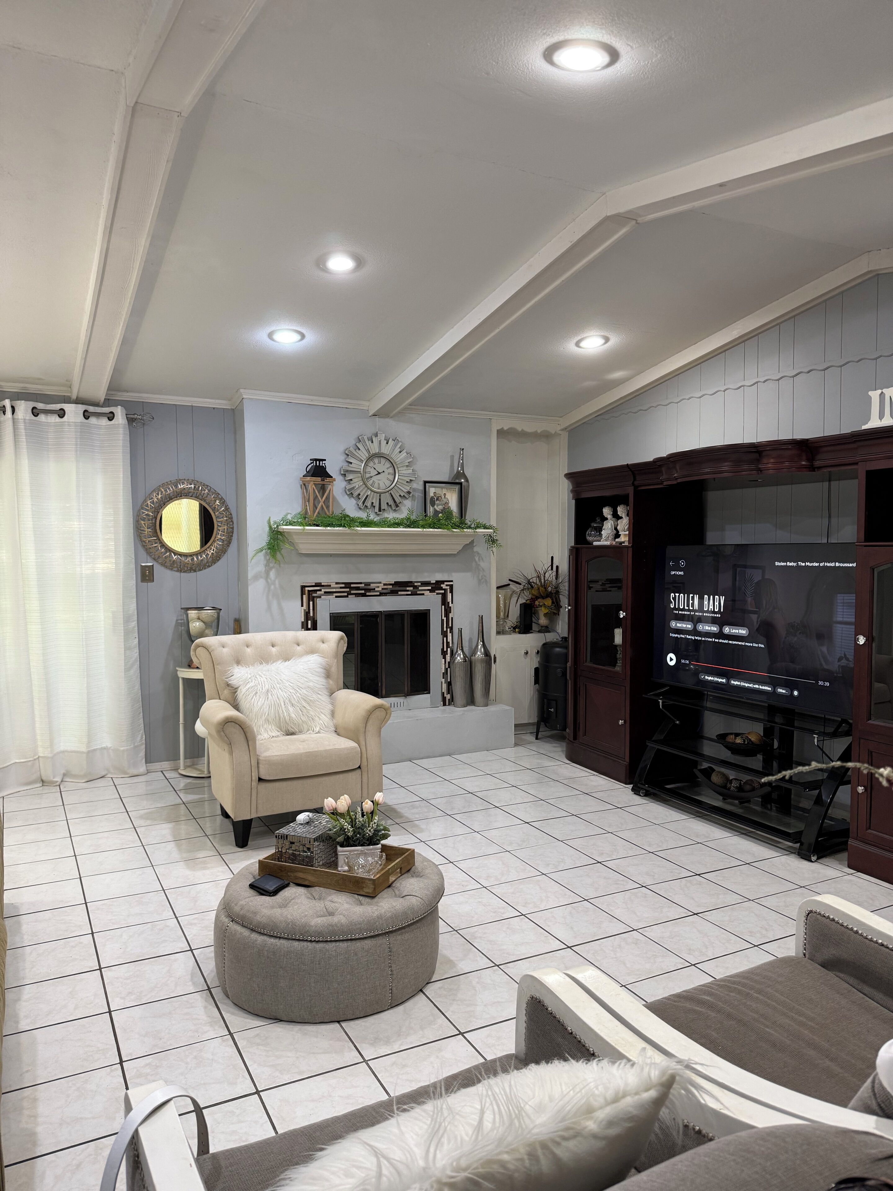 Ein Wohnzimmer mit Kamin, Fernseher und einer gemütlichen Sitzecke.