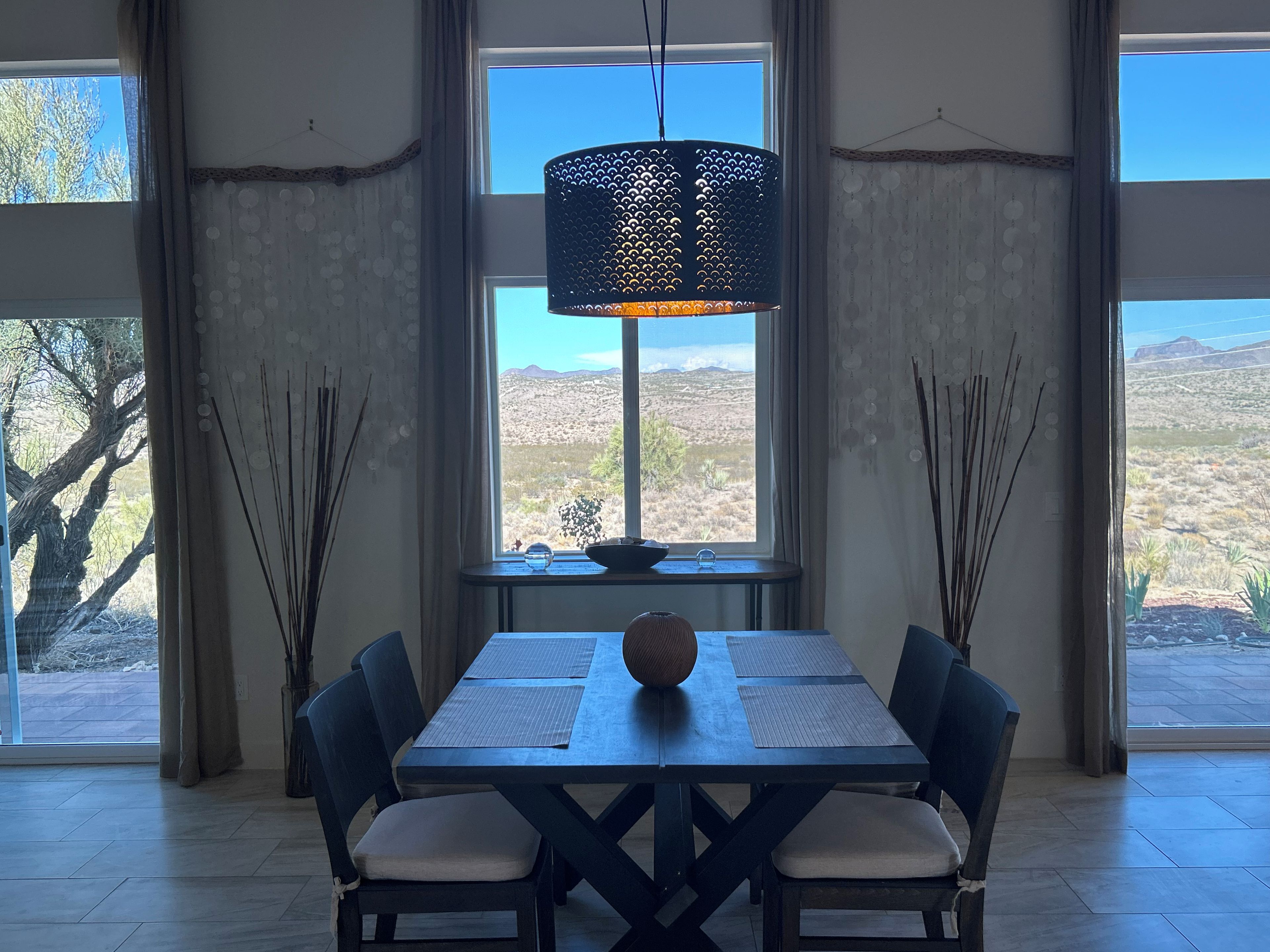 En matplats med ett bord, stolar och en hängande lampa.