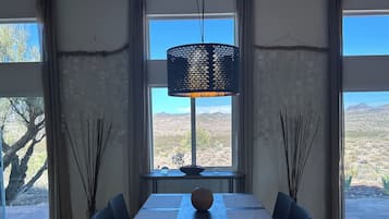 En matplats med ett bord, stolar och en hängande lampa.