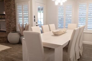 A dining area with a white table and chairs, a decorative bowl, and a brick wall. - Rustic Chateau/Estate -Pool, Spa, Tennis Court, and Quiet, Peaceful Surroundings (Del Rey)