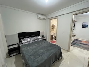 A bedroom with a bed, bedside table, and an air conditioning unit. - Family apartment with great comfort and a great location in Toledo, Paraná. (Toledo)