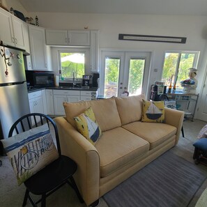 A compact living space with a kitchenette, a sofa, and a dining area.