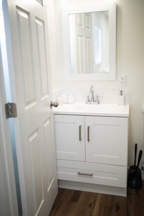 A bathroom with a white vanity, a mirror, and a sink. - Spacious 3-bedroom house in serene Clovis with AC (Clovis)