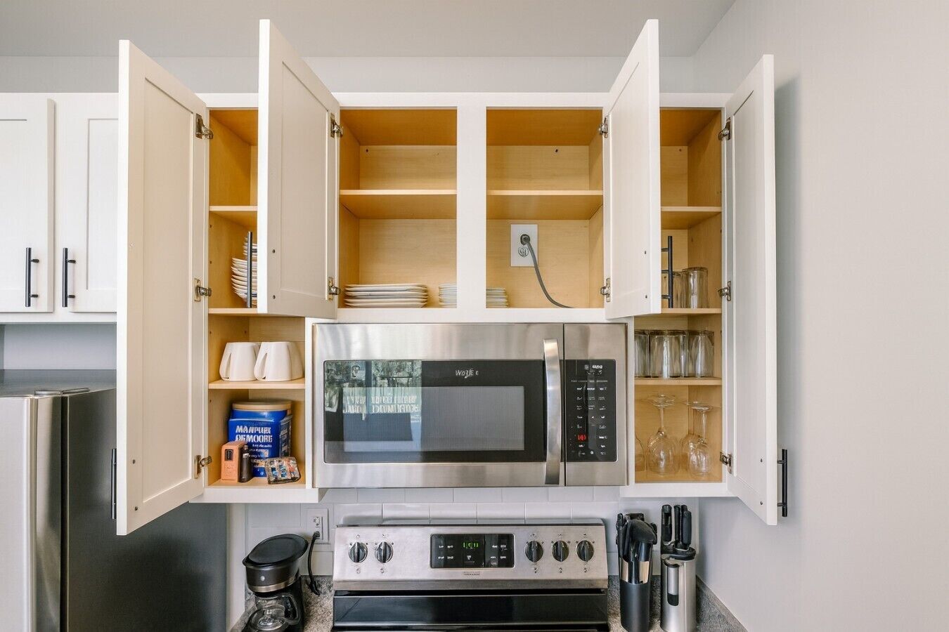 A kitchen with a built-in microwave, oven, and a coffee maker.