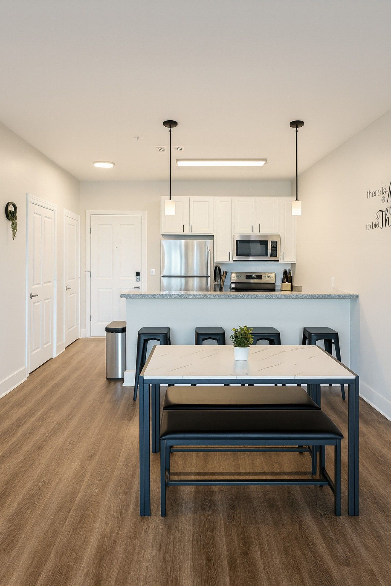 A modern kitchen with white cabinets, stainless steel appliances, and a central island.