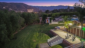 A landscaped outdoor area with a pool, seating, and a staircase leading to a building.
