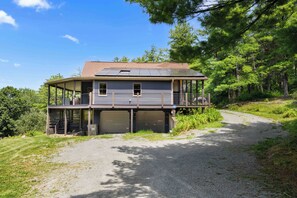 A two-story house with a covered porch and a garage. - Eagle's Landing | Cozy, Pet-Friendly Getaway (Hammondsport)