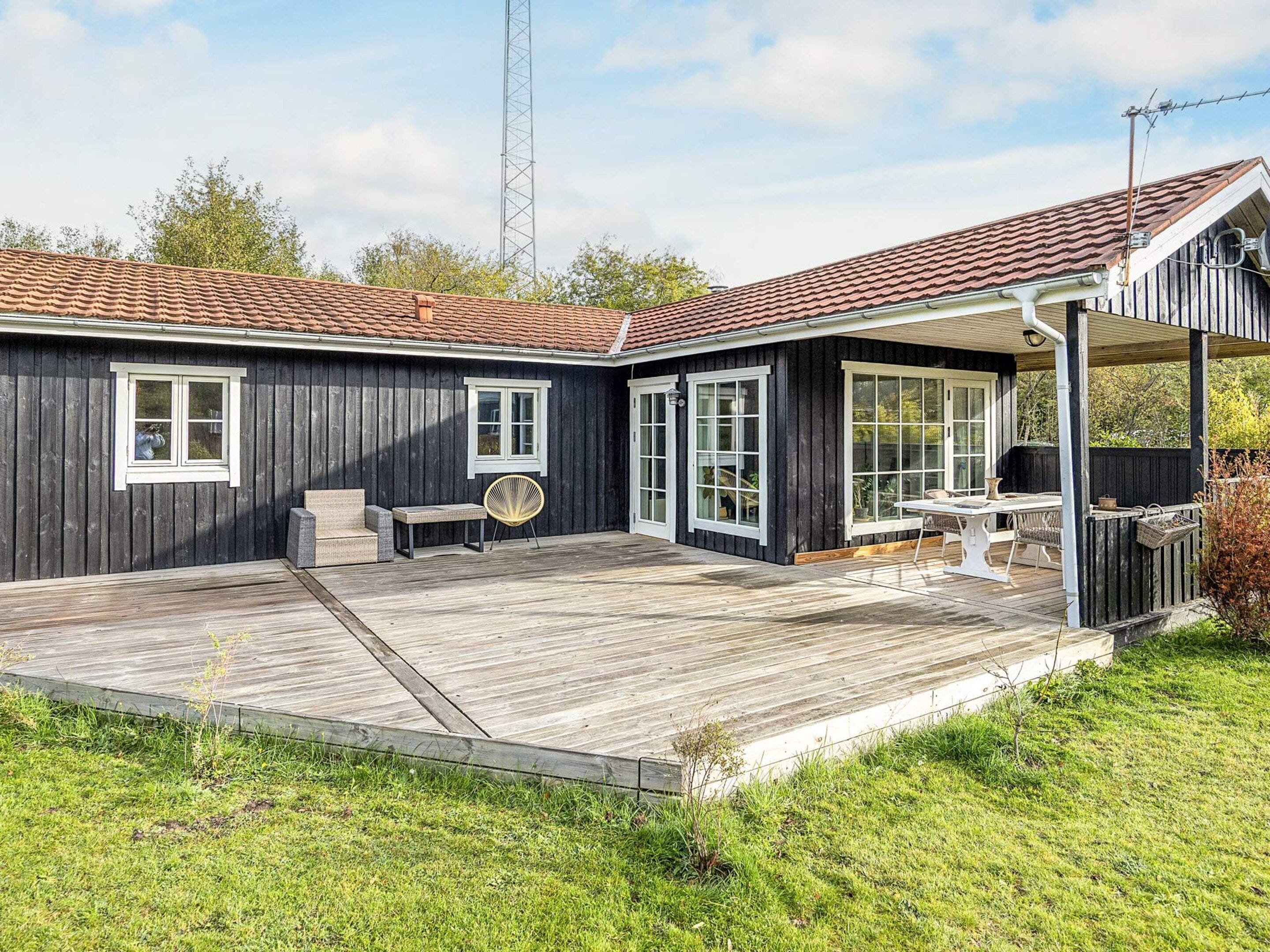 A wooden deck with outdoor furniture, a covered patio area, and a view of the surrounding landscape.