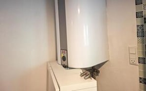 Ein weißer Heizkörper an der Wand, mit Bedienfeld.
