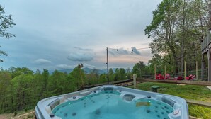 Ein Whirlpool mit Blick auf einen Wald und Berge im Hintergrund.