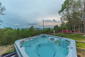 A hot tub with a view of a forest and mountains in the background. - Heated Pool, Hot Tub, Fire Pit & Theater - Asheville (Fairview)