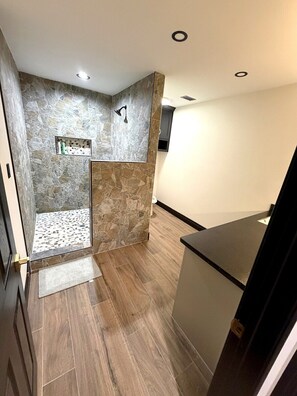 Une salle de bain moderne avec une douche, un meuble-lavabo et un miroir.