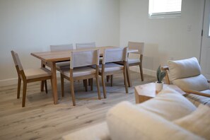 A dining area with a wooden table and chairs, a sofa, and a small plant on a table. - 3-bedroom house in nice Clovis with cool AC for relaxing stays (Clovis)