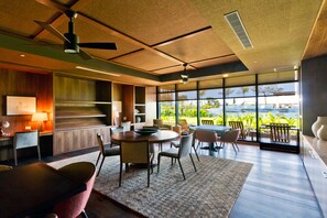 Een modern interieur met een eethoek, keuken en grote ramen met uitzicht op de omgeving.