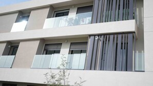 A multi-story building with balconies, large windows, and a flat facade.
