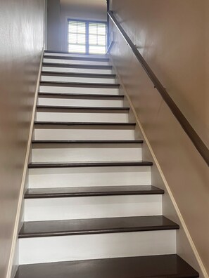 A staircase with a handrail and a window at the top. - Delightful 3-bedroom house with AC in charming Camden (Camden)