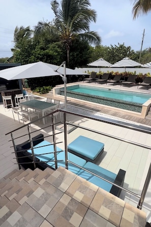Ein Poolbereich mit Pool, Liegestühlen und einer überdachten Sitzgelegenheit.