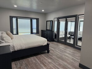 A bedroom with a bed, dresser, and sliding glass doors leading to a balcony.