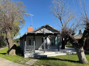 A small, single-story house with a gabled roof, a chimney, and a satellite dish. - Beautiful Rustic 4-bedroom farm house with AC in charming Clovis (Clovis)