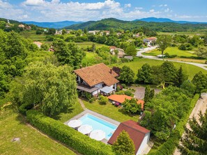A residential property with a swimming pool, surrounded by lush greenery and a hilly landscape. - Villa Bella Cerovlje (Istria - Cerovlje) (Cerovlje)
