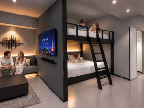 Un interior moderno con una litera, un televisor de pantalla plana, un sofá y una mesa de centro.