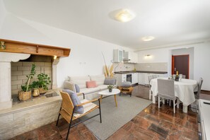 A modern living room with a fireplace, a dining area, and a kitchen. - Villa Morena (Istria - Tinjan) (Tinjan)
