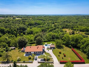 Una propiedad residencial con piscina, una casa independiente y un césped bien cuidado.