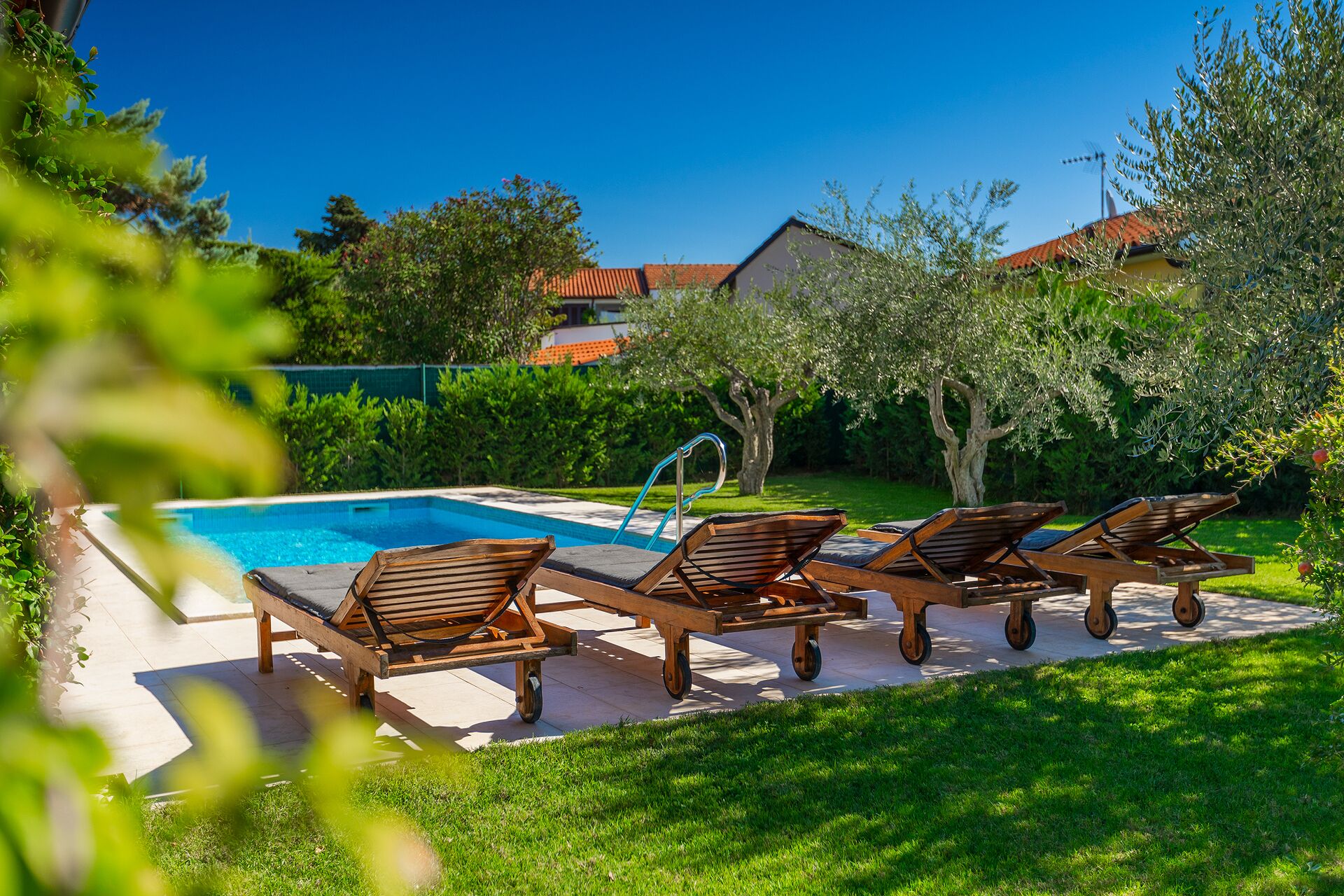 A pool area with lounge chairs and a poolside table.
