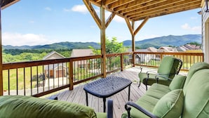 Una terraza techada al aire libre con vistas a un paisaje montañoso.
