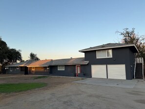 A residential property with a two-car garage, a front lawn, and a satellite dish. - Spacious 4-bedroom house in tranquil Clovis with AC (Clovis)