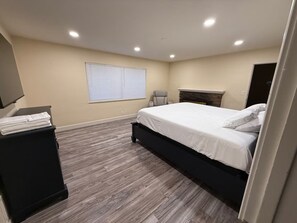 A bedroom with a bed, a desk, a chair, a window with blinds, and a fireplace. - Spacious 4-bedroom house in tranquil Clovis with AC (Clovis)