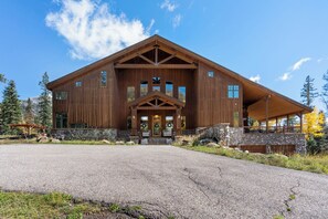 A large wooden lodge with a stone foundation, multiple windows, and a covered porch. - Luxury Mountain Retreat with Panoramic Views, Hot Tub, Game Room, & Endless Outdoor Living (Durango)