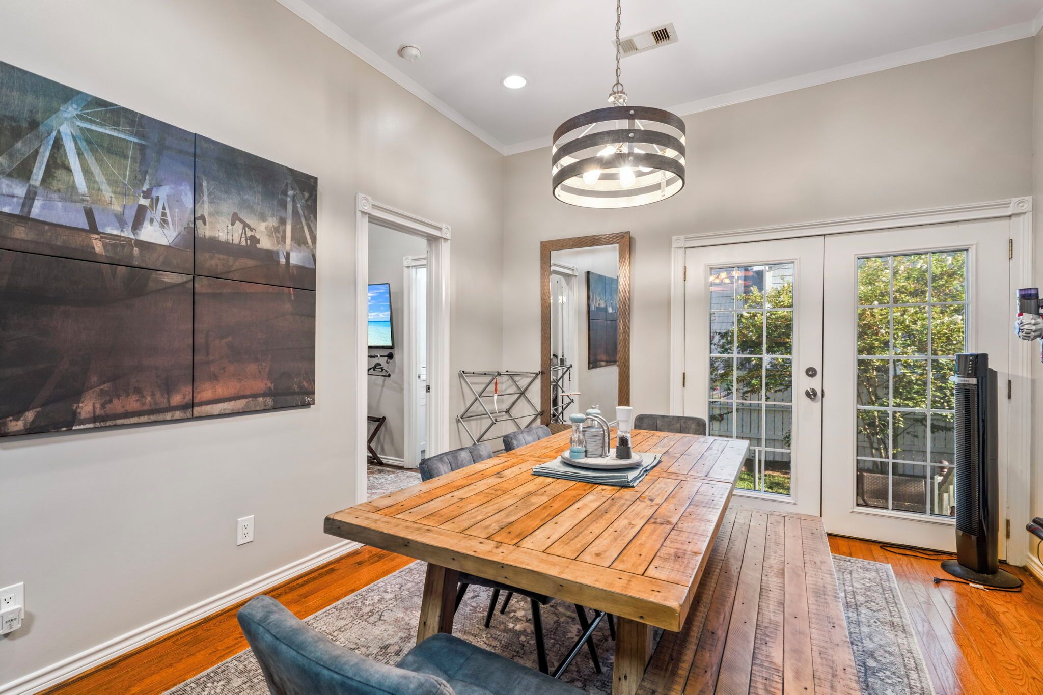 A dining area with a wooden table, chairs, and a pendant light.