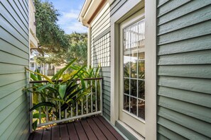 A residential property with a wooden deck, a window, and a plant. - Blue Palms- Steps away from OCEAN (Galveston)