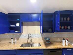 A kitchen with blue cabinets, a stainless steel sink, and a dishwasher. - Gorgeous 3-bedroom apartment with Balcony in vibrant Houston (Houston)