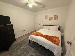 Een slaapkamer met een bed, een kaptafel en kunst aan de muur.