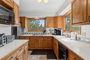 A modern kitchen with wooden cabinets, a microwave, a toaster, and a sink.