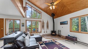 A spacious living room with a fireplace, large windows, and a cozy seating area.