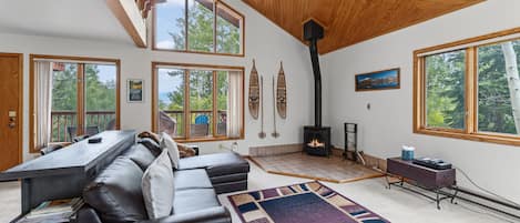 Amplia sala de estar con chimenea, ventanas grandes y un rincón de descanso acogedor.