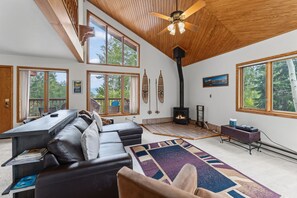 A spacious living room with a fireplace, large windows, and a cozy seating area.