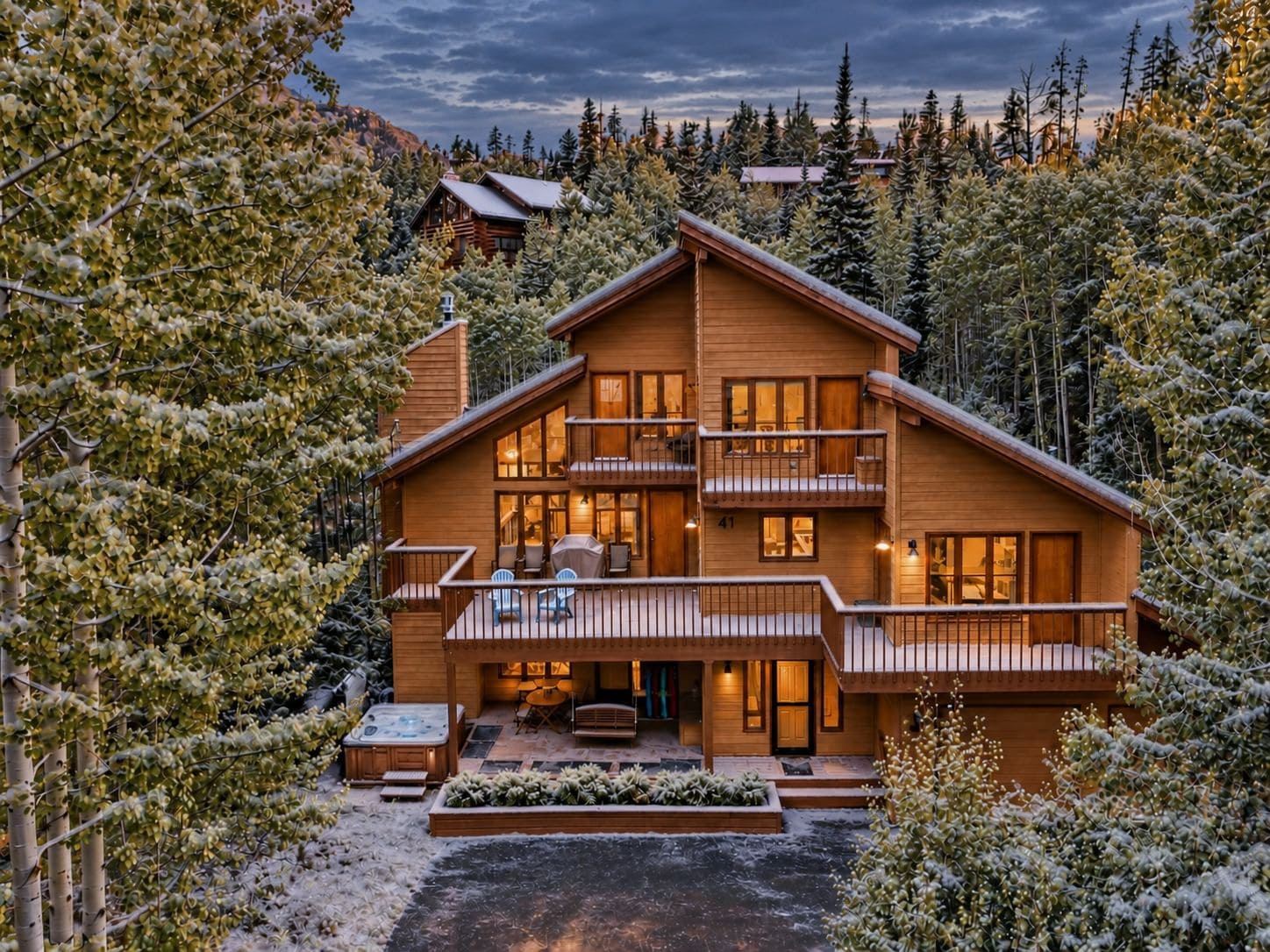 A multi-story wooden lodge surrounded by snow-covered trees.